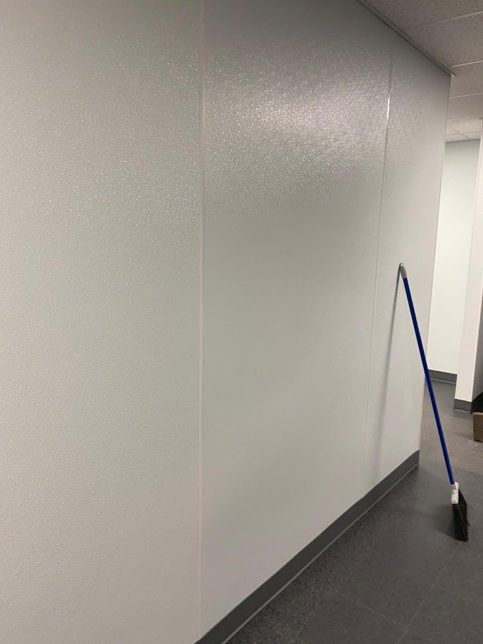 Garage Conversion Services Interior wall finished in smooth painted drywall meeting a plain grey floor